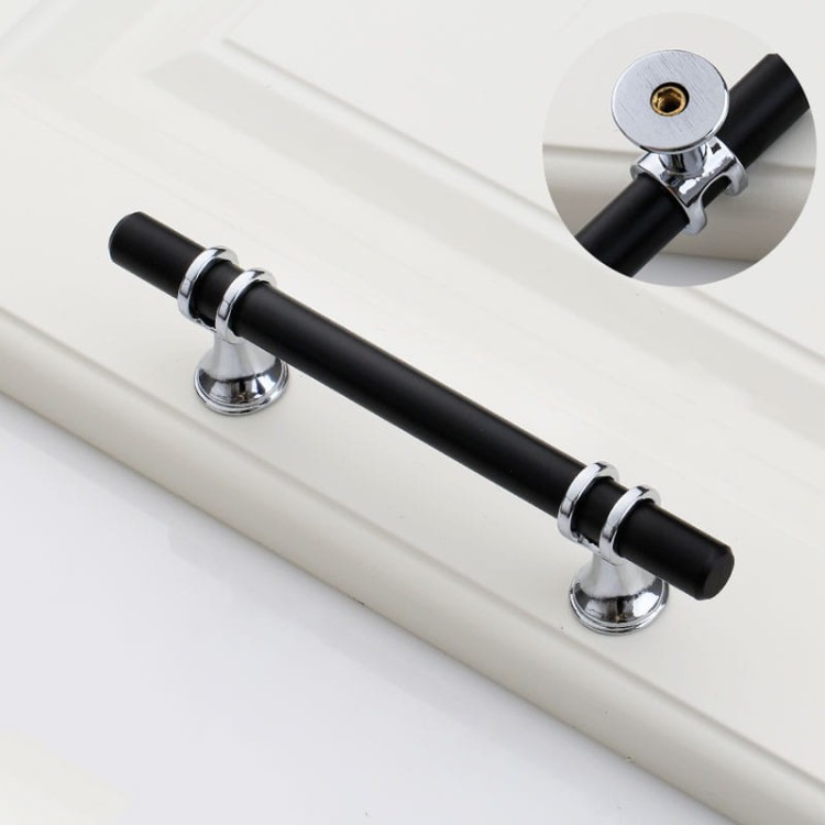 Möbelgriff Pina – eleganter T-Bar-Griff mit dekorativen Stützen in Schwarz-Gold oder Schwarz-Chrom. Als Knopf sowie in 96, 128 und 160 mm erhältlich. Ideal für Schränke, Kommoden und Schiebetüren – egriffe.at