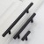 Möbelgriff Uno – T-Bar-Griff mit rundem Profil in Schwarz und gebürstetem Gold. Erhältlich als T-Bar-Knopf sowie in 96, 128, 160, 256, 512 und 850 mm – egriffe.at