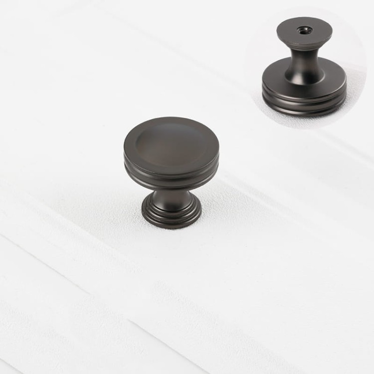 Czarna matowa gałka meblowa Arriba o okrągłym kształcie z widoczną stopką mocującą