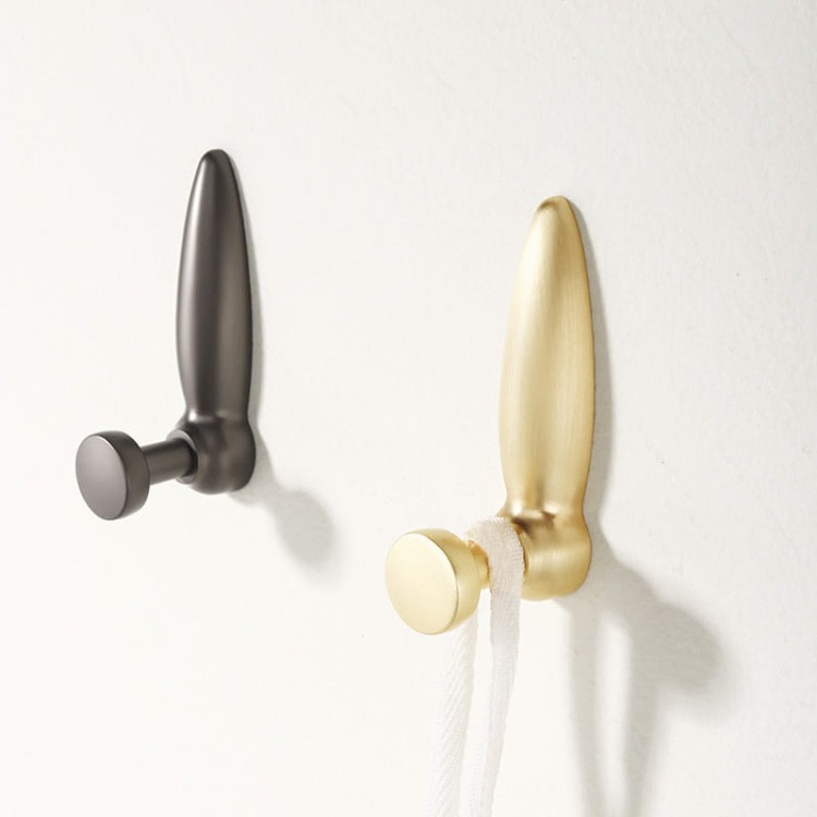 Wandhaken Lumbi mit moderner organischer Form. In gebürstetem Gold und Perlgrau erhältlich – ideal für Zuhause und gewerbliche Räume, einzeln als Akzent oder als Teil einer dekorativen Wandkomposition.