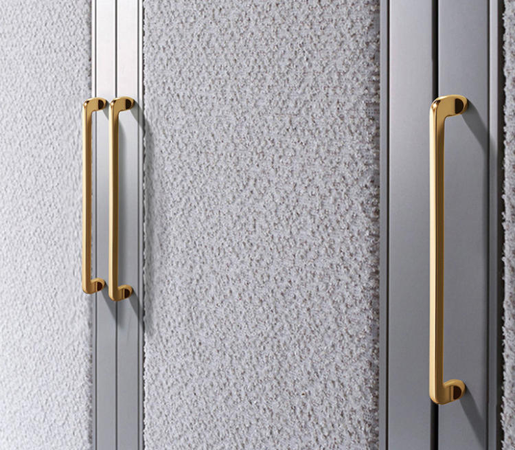 Möbelgriff Lina – universeller Griff in glänzendem Gold und Perlgrau, erhältlich in 128 und 192 mm. Standard-Lochabstand und mitgelieferte Schrauben sorgen für schnelle Montage an Schubladen, Fronten und Türen.
